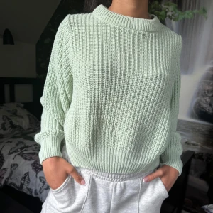 Ljusgrön stickad tröja med struktur - Säljer en ljusgrön stickad tröja med ribbad struktur och rund hals. Tröjan har långa ärmar och en avslappnad passform. Storlek S och köpt från Gina Tricot. 