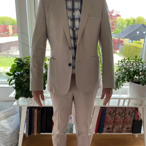 Beige kostym - Snygg beige kostym med matchande kavaj och byxor från Dressman. Kavajen storlek 50 slimfit och byxorna 32-33. 100 för vardera eller 150 för hel sättet. 