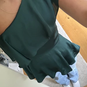 Grön one shoulder top - Säljer super fin one shoulder top med volang