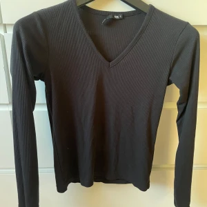Svart ribbad långärmad tröja från 157 -  Säljer en ribbad långärmad tröja från lager 157!! Den är jättefin, men den sitter lite kort vid magen men perfekt i armarna!! den sitter även bra vid brösten och den är i bra skick! Har använt fåtal gånger!💞 