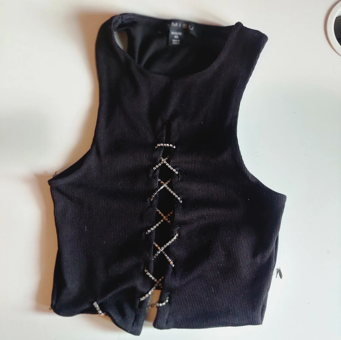 Svart ribbad linnetopp med snörning