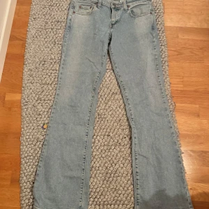 Ljusblå jeans från Levi's - Säljer dessa ljusblå Levi's jeans i modellen super low bootcut. Köpta här på Plick men aldrig använda då de var i fel storlek. Tråden på ena fickan har lossnat lite men tror det är lätt att fixa! De är i storlek w31 och längd 33