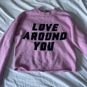 Rosa tröja från Divided - Säljer en söt rosa tröja från Divided med texten 'LOVE AROUND YOU' i svart på framsidan. Tröjan har långa ärmar och en rund halsringning.💖säljer för jag aldrig använder. 