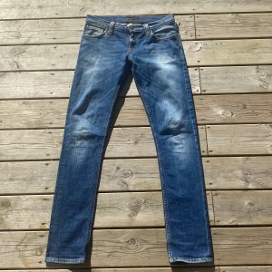 Blå jeans från Nudie Jeans - Snygga blå jeans från Nudie Jeans med en klassisk femficksdesign och subtila slitningar. Modellen är grim Tim och dem är i ett fantastiskt skick utan några som hellst defekter dem är köpta på Care of Carl för ca 1600 kr säljer nu endast för 400 hör av er vid minsta fråga, först till kvarn gäller mvh✅😀
