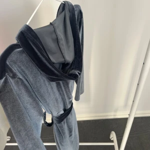 Grå långklänning från Hemtex - En morgonrock i mjukt sammetstyg från Hemtex.  Har ett knytband i midjan för en smickrande passform. Perfekt för en stilren och sofistikerad look.🩷