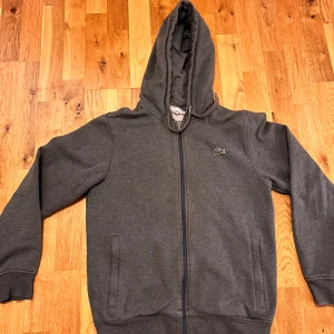 Lacoste zip hoodie - Zip hoodie från lacoste, har inga defekter så är i mycket bra skick. Skriv innan du köper då annonsen ligger ute på flera plattformar💗