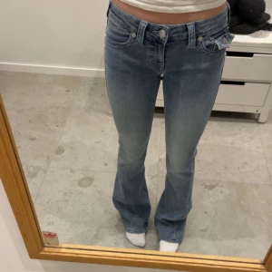 Blå bootcut jeans - Säljer mina ljusblåa true religion jeans i stilen joey i storlek 25 som är slutsålda online. Endast använda fåtal gånger och har inga defekter. Säljer då de är lite långa på mig.