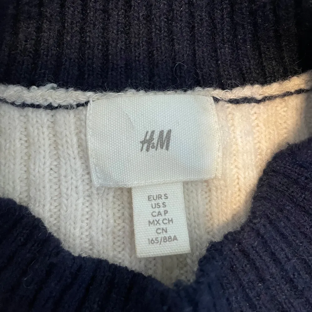 Säljer en snygg randig stickad tröja från H&M i svart och beige. Tröjan har en klassisk rund hals och långa ärmar. Den ribbade strukturen ger en extra touch av stil. . Neuletakit & Villapaidat.