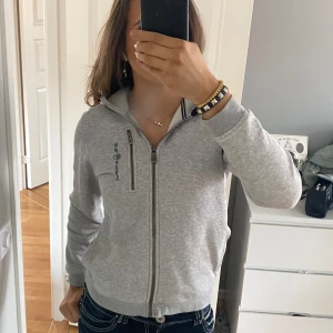 Grå hoodie från Sail Racing - Säljer en stilren grå hoodie från Sail Racing. Den har en dragkedja framtill och en praktisk huva. Perfekt för en avslappnad look, storlek 160 men passar mig som oftast bär xs/s. Hör av dig vid intresse! Pris kan diskuteras 