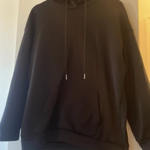 Svart hoodie med tryck - Snygg svart hoodie med ett stort tryck på baksidan som föreställer en klassisk staty med texten 'INTENSE FEELINGS'. Hoodien har en känguruficka och dragsko vid huvan.