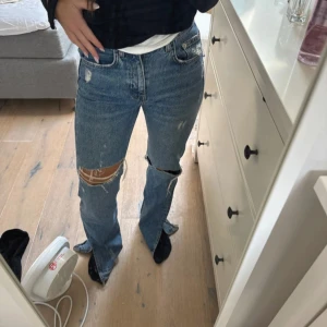 Blå jeans från Pull&Bear - Snygga blå jeans från Pull&Bear med slitna detaljer och hål vid knäna. Lite smutsiga vid ena benet längst ner men inget som tydligt syns!