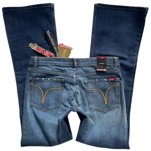 Lågmidjade bootcut jeans från Blend She - Nya medium-mörkblåa lågmidjade bootcut deadstock jeans med lappar kvar 💙MIDJEMÅTT: 82.6 cm + stretch. INNERBENSLÄNGD: 78 cm. GRENDJUP: 19.5 cm. Jag brukar ha strl S i byxor och är 1,67 för referens! 
