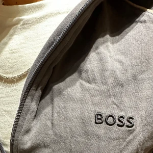 Grå hoodie från Boss - grå tunn hoodie från Boss med dragkedja framtill. 