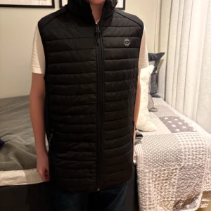 Svart Jack and Jones Väst - Helt NY! Jack and Jones väst.  Storlek XS. Modellen är 162 och väger 49 kg. Pris kan diskuteras vid snabb affär! Hör av er om ni har några frågor! Kan köpas i bundle med mina andra varor för ett billigare pris! Perfekt inför våren och sommaren!
