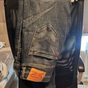 Levis 520 jeans - Säljer ett par klassiska blå jeans från Levi's med den ikoniska läderpatchen och bakfickor med dekorativa sömmar. Perfekta för en avslappnad stil.