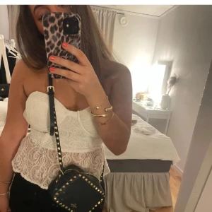 Vit spetskorsett - Vit korsett i spets med volangdetaljer. Den har en dragkedja i ryggen och är axelbandslös! 🤍🤍🤍Pris kan diskuteras 