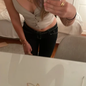 Beige ribbad linnetopp - Snygg beige ribbad linnetopp med knytning framtill. Toppen är ärmlös och har en djup v-ringning som ger en trendig look. Perfekt för en stilren outfit💕 Använda ca 2 gånger