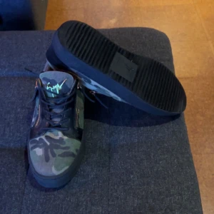 Giuseppe Zanotti skor - Snygga sneakers med camouflage-mönster och svarta detaljer. Skorna har både snörning och dragkedja för en cool look. Perfekta för en avslappnad stil.   Sparsamt använda fåtal gånger