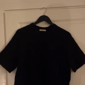 Svart stickad t-shirt från Gina Tricot - Säljer min stickade t-shirt ifrån gina tricot då jag inte använder den. Fint skick, inga noppror, använd fåtal gånger och väldigt snygg. Pris kan diskuteras.
