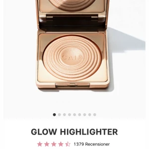 Glow Highlighter Sydney från CAIA - Snygg glow highlighter från CAIA i ton Sydney  i en elegant guldtonad förpackning. Den har en skimrande finish som ger en strålande lyster. Perfekt för att framhäva kindben och andra ansiktsdrag. Kompakt design med spegel för enkel applicering.