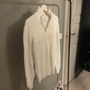 Vit stickad half-zip Zara - Säljer denna stilrena half-zip tröjan från Zara. Tröjan är i ett bra skick men finns tecken på användning.