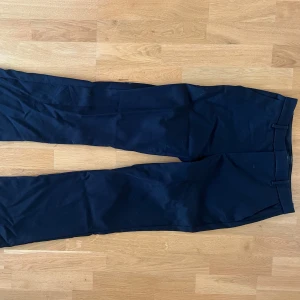 Svarta kostymbyxor från Lindex - Snygga svarta kostymbyxor från Lindex, modell Fiona. Byxorna har hög midja, raka ben och lite bootcut modell. De är i storlek 36 och är långa i benen, perfekt längt för mig som är 172cm. Mycket bra skick, endast använda två gånger.
