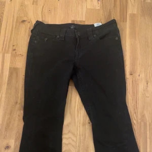 Svarta True Religion Jeans  - Säljer ett par svarta True Religion Joey Low Rise Flare jeans i storlek 28. Säljer pågrund av dom inte kommer till användning. Pris går att diskutera och skriv för flera bilder🌸
