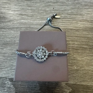 Pearls for girls - Amie Bracelet - Silver armband med en blomliknande hänge, armbandet är justebart i längden och nickelsäkert. Använt fåtal gånger, säljer pågrund av byte till guldsmycken!😊💕