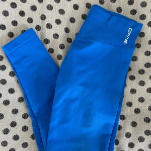 Blå träningstights från DFYNE - Säljer ett par blå träningstights från DFYNE, modell Impact. Snyggaste och skönaste träningstightsen jag vet men tyvärr lite för små för mig. Har därav blivit använd endast någon enstaka gång. True  to size.