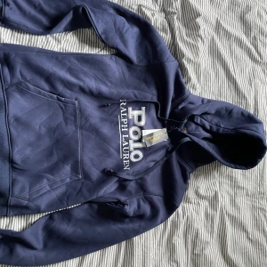 Mörkblå hoodie från Polo Ralph Lauren - Säljer en mörkblå hoodie från Ralph lauren i riktigt fint skick🤩🤩passade inte mig. Storlek xl men passar som L