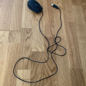 Svart USB-datormus med sladd - Säljer en svart datormus med USB-anslutning och lång sladd. Musen har flera knappar och en rullhjul. Passar bra till gaming eller arbete vid datorn.