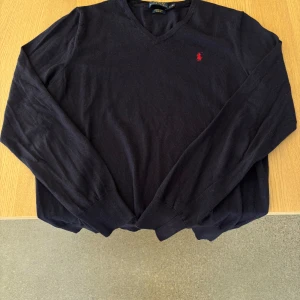 Svart merinoullströja från Polo Ralph Lauren - Säljer en svart långärmad tröja från Polo Ralph Lauren i merinoull. Tröjan har v-ringning och en röd broderad logga på bröstet. Slim fit-modell, storlek L men passar även M. Hör av vid funderingar👍🏻