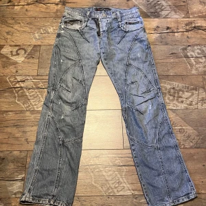 Feta blåa jeans - Säljer ett par blå jeansbyxor  med unika sömmar och dragkedjedetaljer