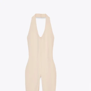 Beige jumpsuit med halterneck - Snygg beige jumpsuit med halterneck och utsvängda ben. Perfekt för dig som vill ha en stilren och trendig look. Jumpsuiten har en figurnära passform och stängs i nacken.