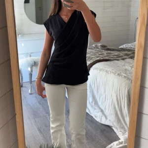 Svart omlottopp med broderade detaljer - Snygg svart omlottopp med små broderade hål och draperad framsida🫧☀️🌊🤍