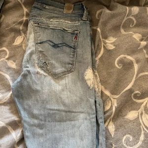 Dam Ljusblå slitna skinnyjeans från Replay - Ljusblå jeans från Replay med tydliga slitningar och trasiga detaljer på både fram- och baksida. Klassisk femficksmodell med normal passform och raka ben. Perfekta för en avslappnad och trendig look.