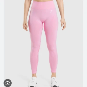Rosa träningstights från Gymshark - Säljer ett par ljusrosa träningstights från Gymshark med hög midja och tight passform. Tightsen är sömlösa och har en diskret logga framtill och baktill. Helt slutsålda på hemsidan storlek S