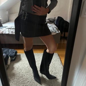 Mörkgrå minikjol med bältesdetalj - Säljer en mörkgrå minikjol som aldrig är använd💛