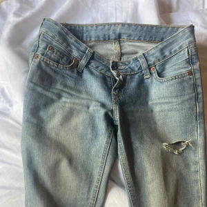 Lågmidjade Levis jeans med slitning - Säljer ett par klassiska ljusblå Levis jeans som är väldigt lågmidjde! En snygg slitning på ena låret. De är i bra skick, jag säljer då de är lite för små för mig. Pris kan såklart diskuteras, bara att fråga om mått eller annat💕💕Skulle säga storlek 25/32 men det står inte inuti. Jag är 164 som referens 🌟