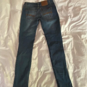 Nudie Jeans - Säljer ett par klassiska blå jeans från Nudie Jeans. Jeansen har normal passform, raka ben och klassisk femficksmodell. Storlek 28