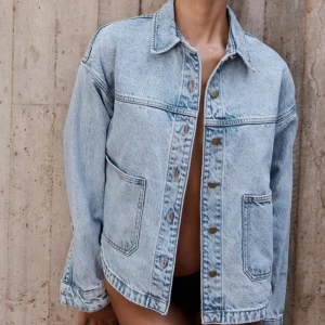 Ljusblå jeansjacka från Zara - Säljer en klassisk ljusblå jeansjacka från Zara med raka linjer och stora framfickor. Jackan har knappar framtill, krage och långa ärmar. Perfekt för en avslappnad och trendig look. Inga defekter, använd köp nu så postar jag så snart som möjligt! Modellen är samma som den populära gröna jeansjackan🩷