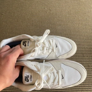 Nike SB Alleyoop vita sneakers - Säljer ett par fräscha Nike SB Alleyoop sneakers i vitt med svarta detaljer och klassisk swoosh. Helt nya, Köpte för ett tag sedan men det passade inte så därför jag säljer.  Passar som 42.5