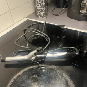 Locktång från Coline - Säljer en svart och silver locktång från Coline med smal cylinder och enkel on/off-knapp. Perfekt för att skapa fina lockar eller vågor i håret. Ergonomiskt handtag och lång sladd för smidig användning.