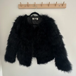 Svart pälsjacka från DM - Säljer en svart fluffig pälsjacka från DM Dennis. Tagit hand om den väl!