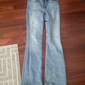 Ljusblå bootcut jeans från 157 - Säljer ett par ljusblå bootcut jeans från 157 i storlek XS. Jeansen har normal passform, utsvängda ben och råa, fransiga benslut för en trendig look. Perfekta till vardags med en enkel topp eller hoodie.
