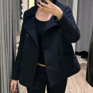 Massimo Dutti kappa - Säljer en mörkblå kappa med dubbelknäppning och bred krage. Jackan har lång ärm och en klassisk, stilren look som passar till många outfits. Den är från Massimo Dutti i storlek xs/s.