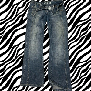 Blå bootcut jeans med låg midja - jeansen är i storlek 38 men de passar mellan 34-40 eftersom att de är ett bälte i midjan. Snygga blå jeans från YMI Jeans med låg midja och bootcut passform. Jeansen har slitningar och ljusare partier framtill, klassiska fickor och bälteshällor. 