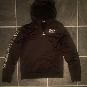 Svart EA7 hoodie med dragkedja - Svart hoodie från EA7 Emporio Armani med silver logor i storlek M