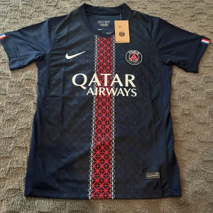 PSG matchtröja Nike marinblå röd - Produktinfo: 	•	🧵 Nike Dri-FIT material – officiell produkt 	•	🇫🇷 “ICI C’EST PARIS” tryck i kragen 	•	🪪 ENGINEERED tagg med serienummer 	•	✨ Detaljerad design med Qatar Airways sponsor 	•	👕 Storlek: S (Small) 	•	🌍 Tillverkad i Thailand 🛍️ Perfekt för: ✔️ Samlare ✔️ PSG-fans ✔️ Träning, match eller vardagsstil  💸 Prisidé: [600 kr taggen finns inte  ⚠️ Först till kvarn – tröjan är EXKLUSIV och svår att få tag på! Hör av dig vid frågor! 🙌