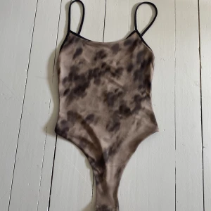 Festtopp - Säljer en mesh body från H&M i storlek XS. Bodyn har ett coolt, abstrakt mönster som påminner om militärmönster🩷Materialet är dubbelt på framsidan och enkelt på baksidan! Endast testad!               PRISET KAN DISKUTERAS